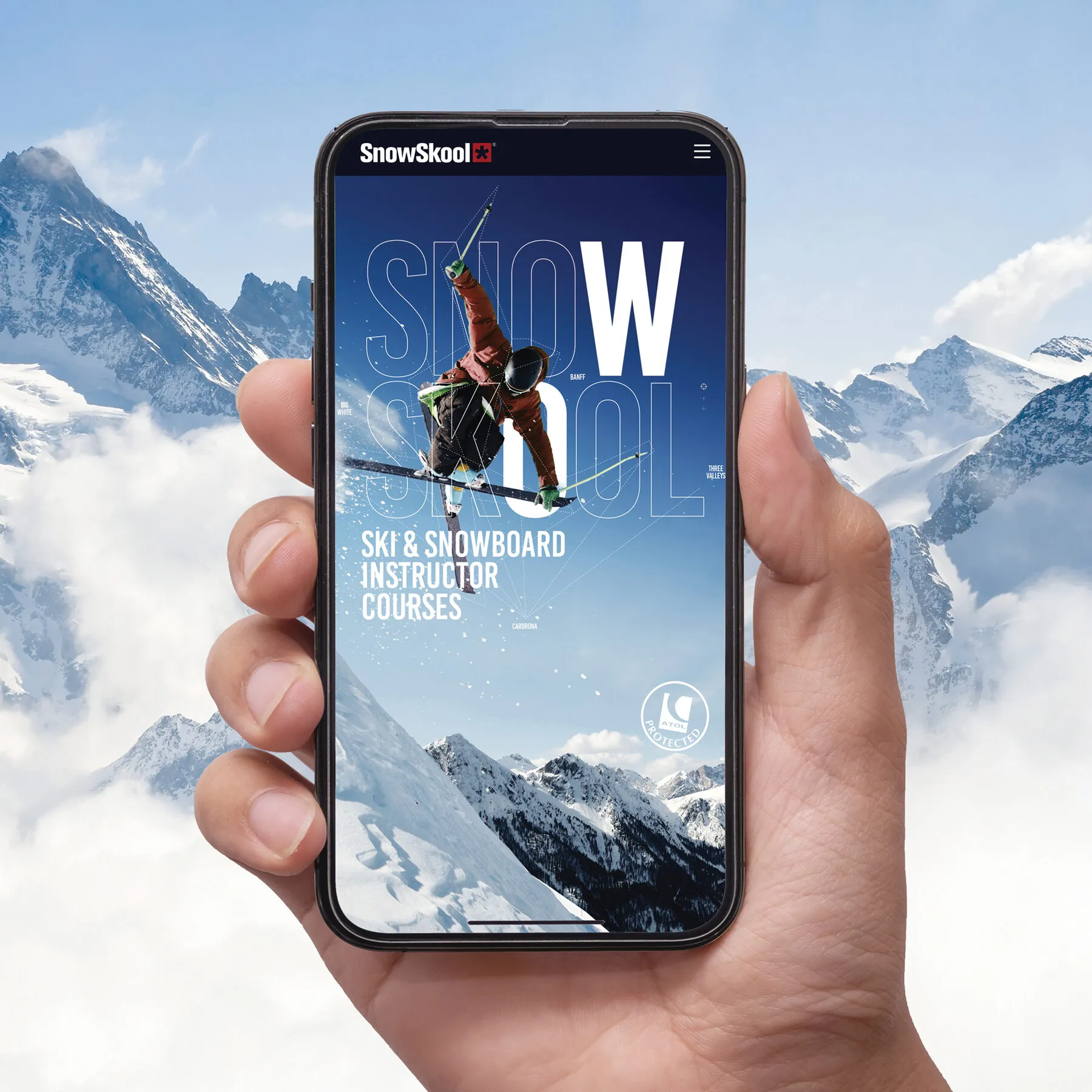 A hand holding a phone showing the SnowSkool website