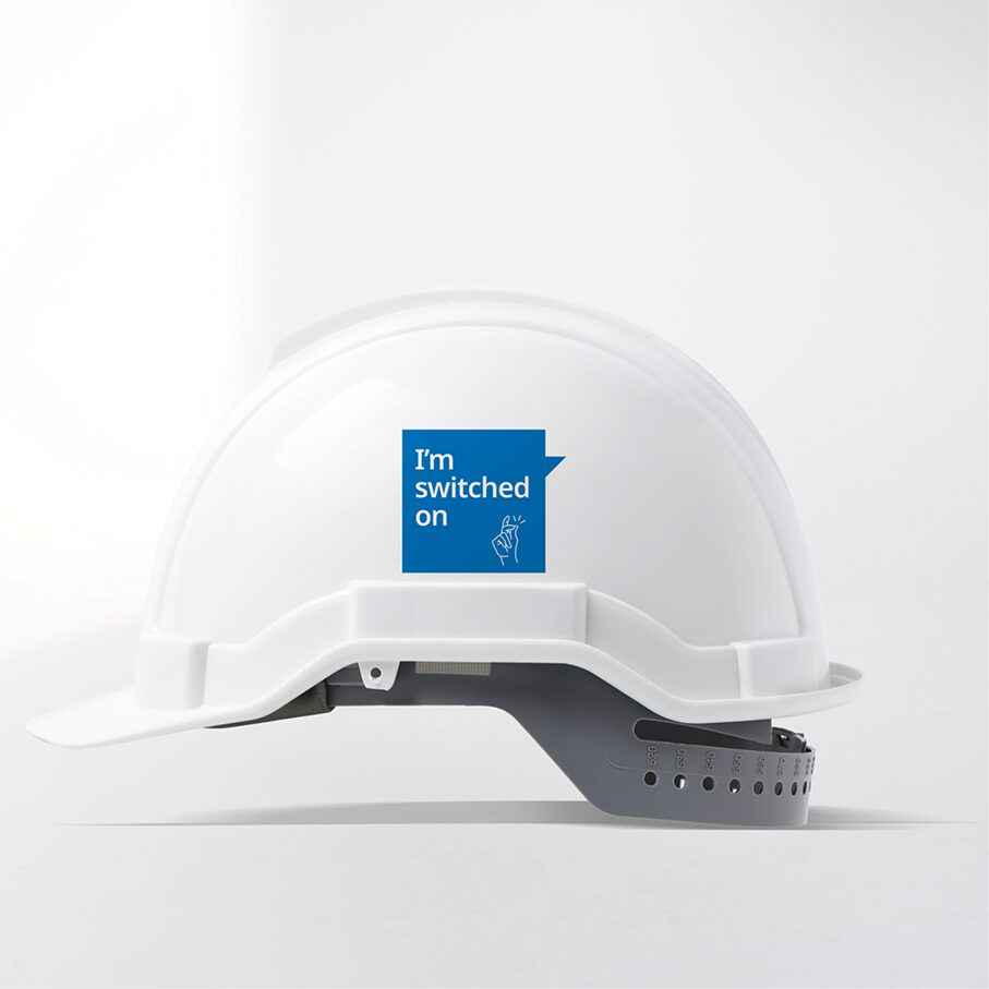 A white hard hat carrying a ‘Switched on’ sticker